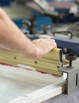 a hand operating a printing machine